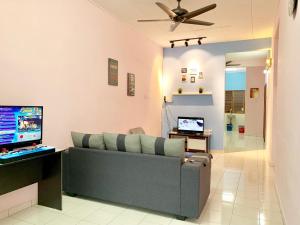 sala de estar con sofá y TV en Kampar Sakura 2 Landed en Kampar