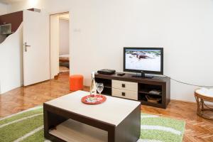 a living room with a tv and a coffee table at Apartment Old Town in Herceg-Novi