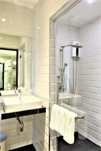 y baño blanco con lavabo y ducha. en Marwin Space, en Bangkok