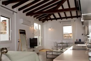 ein Wohnzimmer mit weißen Wänden und Holzdecken in der Unterkunft Atico San Nicolás in Toledo