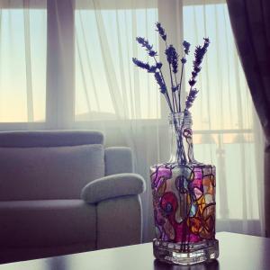 eine Glasvase mit Blumen auf dem Tisch in der Unterkunft Zen Apartment Oradea - FREE Parking in Oradea