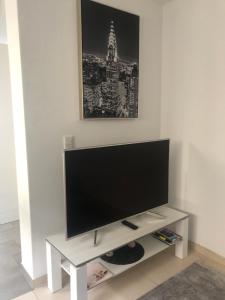 TV de pantalla plana en un soporte blanco en una habitación en Casa Gazzo, en Friedrichshafen