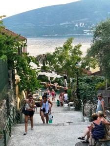 eine Gruppe von Menschen, die einen Bürgersteig am Strand entlang laufen in der Unterkunft Apartment Old Town in Herceg-Novi