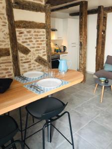 cocina con mesa de madera y sillas en Joli appartement quartier historique en Moulins