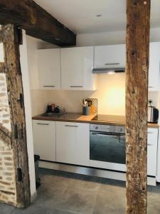 eine Küche mit weißen Schränken und einem Herd in der Unterkunft Joli appartement quartier historique in Moulins