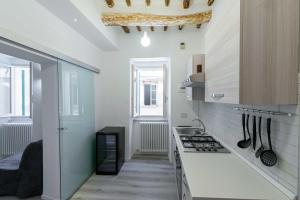 een keuken met witte muren en een aanrecht met keukengerei bij Pasticcio Guest House in Perugia
