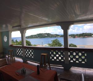 a view of the water from a restaurant with tables and chairs at Harbour Vista Inn in Castries