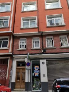 un edificio de ladrillo rojo con un cartel frente a una tienda en Ático encantador..., en A Coruña