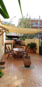 une terrasse avec une table, des chaises et un parasol dans l'établissement Casa con Giardino privata nel Centro Città, à Velletri