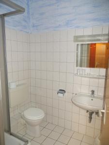 a white bathroom with a toilet and a sink at Heidehotel Letzlingen in Letzlingen