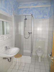 uma casa de banho com um chuveiro, um lavatório e um WC. em Heidehotel Letzlingen em Letzlingen