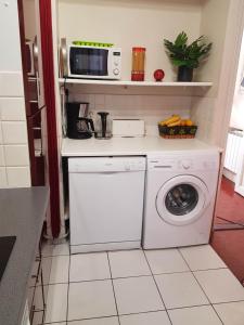 a kitchen with a washing machine and a microwave at Magenta in Menton