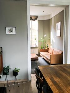 uma sala de estar com uma mesa e um sofá em Domus Portus em Dendermonde