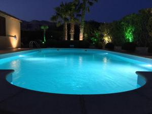 una gran piscina de agua azul por la noche en VILLA ANNA MARIA, en Custonaci
