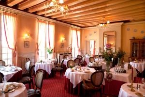 a dining room with tables and chairs with white table settings at Château de Beaulieu et Magnolia Spa, The Originals Relais in Joué-lès-Tours