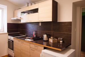 a kitchen with wooden cabinets and a black counter top at Penzion Poruba in Ostrava