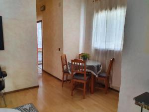 jadalnia ze stołem i krzesłami oraz oknem w obiekcie Ático en el Corazón de Sevilla w Sewilli