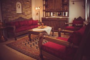 - un salon avec des canapés rouges et une table dans l'établissement ARCHONTIKO XANTHI, à Makrinitsa