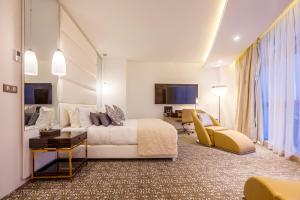 Großes Hotelzimmer mit einem Bett und einem Sofa in der Unterkunft Ferdi Lilly in Ben ʼAknoûn