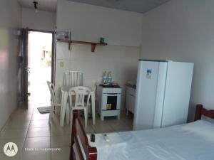cocina con nevera, mesa y sillas en Residencial Dom Fernando en Belém