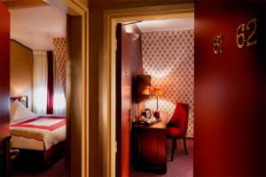 Pokój hotelowy z sypialnią z łóżkiem i biurkiem w obiekcie Hotel Britannique w Paryżu