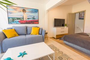 Apartamento - OASIS في مورو جابل: غرفة معيشة مع أريكة زرقاء وسرير