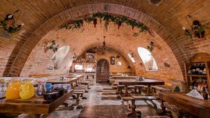 a restaurant with wooden tables and a brick wall at Apartmány Pod Čerťákem in Dolní Moravice