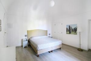 Dormitorio blanco con cama y lámpara en Casa Maria Grazia, en Positano