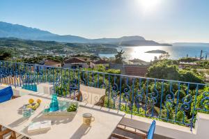 balcón con mesa y vistas al océano en Villa Myrina with Sea View BY APOKORONAS-VILLAS, en Plaka
