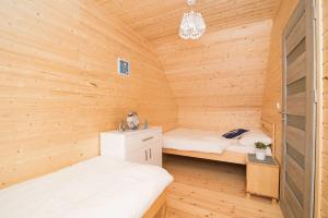 a room with two beds in a wooden cabin at Domki Wakacyjne Wybrzeże in Mielno