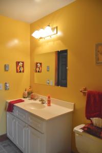 a bathroom with a sink and a mirror and a toilet at Yellow Door Bed and Breakfast in Crystal Beach