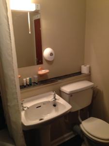 a bathroom with a toilet and a sink and a mirror at The White Swan Hotel in Duns