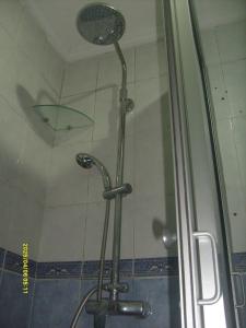 a shower with a glass door with a umbrella at Appartement Aznavour in Casablanca