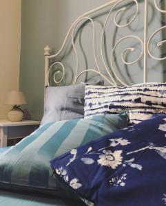 un letto con lenzuola e cuscini blu e bianchi di Casa Azzurra a Bagheria