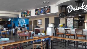 Un restaurante con barra, mesas y sillas. en Sunset 786 Holiday Accom-212, en Strand