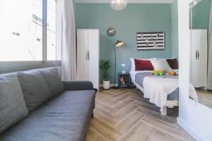 een woonkamer met een bed en een bank bij Monochrome Rothschild - Smart Hotel by Loginn Tel Aviv in Tel Aviv