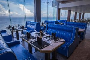 a restaurant with blue chairs and tables and the ocean at Regal Réseau Hotel & Spa in Negombo