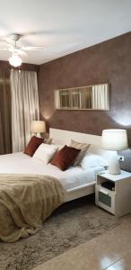 a bedroom with a large white bed with brown pillows at Apartment next to the beach in Portals Nous