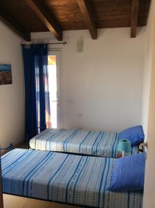 2 camas en una habitación con ventana en Soggiornare a Cagliari, en Cagliari