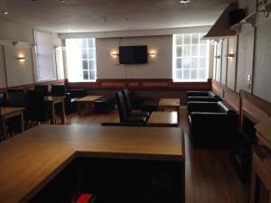 a waiting room with chairs and a flat screen tv at The White Swan Hotel in Duns