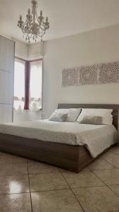 a bedroom with a large bed and a chandelier at Elena’s home in Cagliari