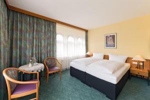 une chambre d'hôtel avec un lit, une table et des chaises dans l'établissement Hotel Katharinenhof, à Werdau