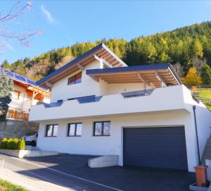 une maison blanche avec un garage dans l'établissement Alpenapart Gastl, à Arzl im Pitztal