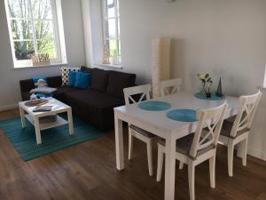 - un salon avec une table, des chaises et un canapé dans l'établissement Am Deich 13, à Kollmar