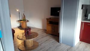 sala de estar con mesa y TV en Meublé de charme proche du centre ville, en Niederbronn-les-Bains