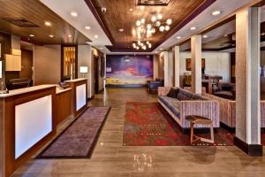 a lobby of a hotel with a couch and a bar at Holiday Inn Express Hutchison, an IHG Hotel in Hutchinson