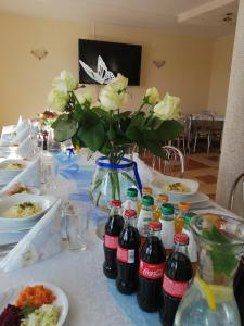 ミチュコフツェにあるNoclegi Pod Bukowinąの花瓶とソーダボトルを用意したテーブル