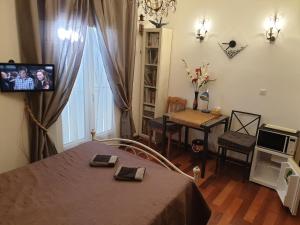a room with a bed and a television and a table at REDHOUSE Chambre zen in Roques Sur Garonne