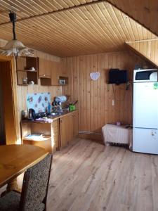 eine Küche mit einem Tisch und einem weißen Kühlschrank in der Unterkunft Ансол in Worochta