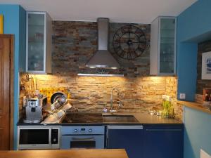 Una cocina con un fregadero y un reloj en la pared. en REDHOUSE Chambre zen, en Roques Sur Garonne